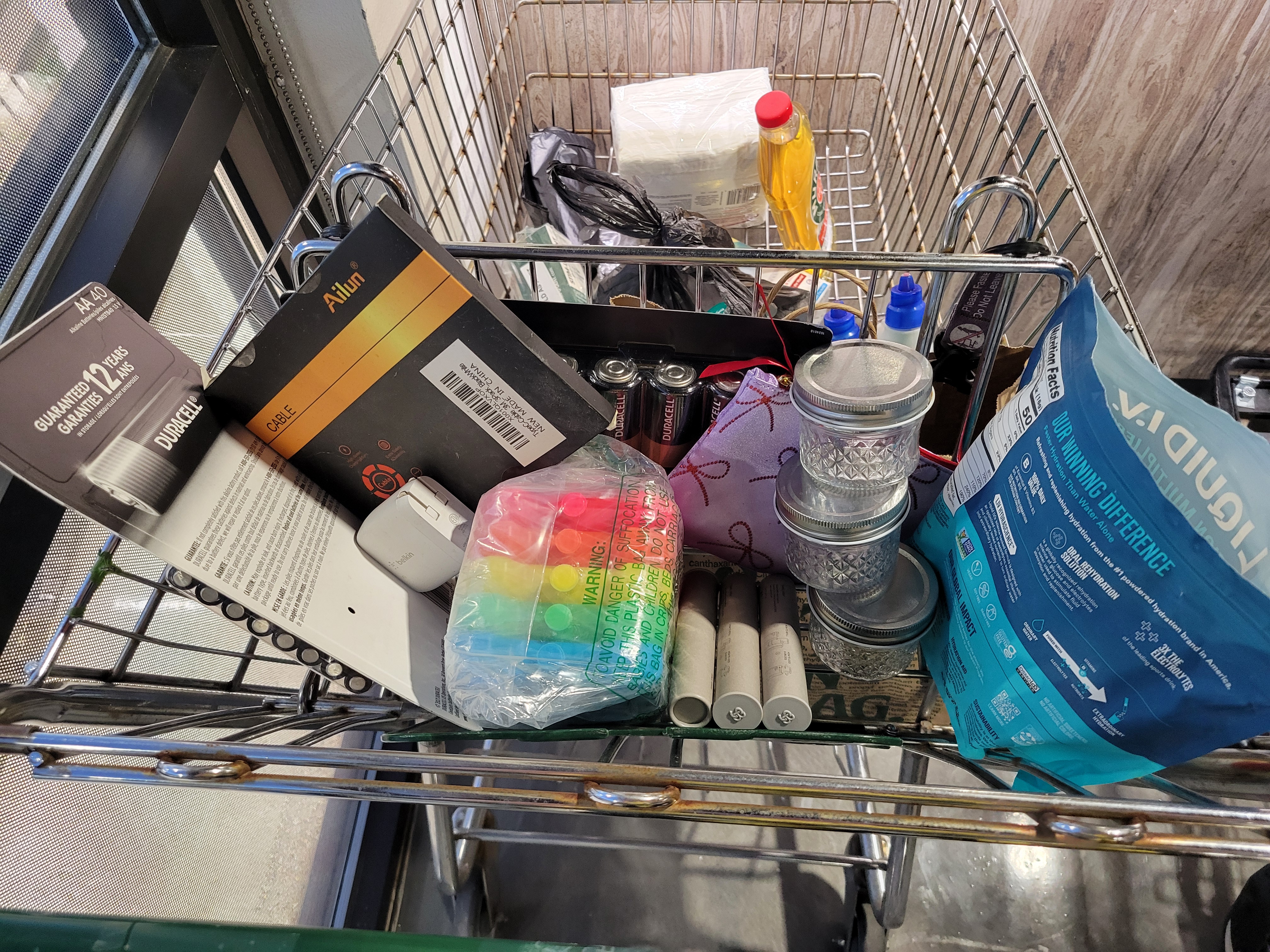 Miscellaneous household items in a shopping cart.